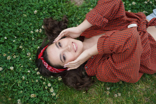 A girl lies on her back on the grass - Фото, зображення