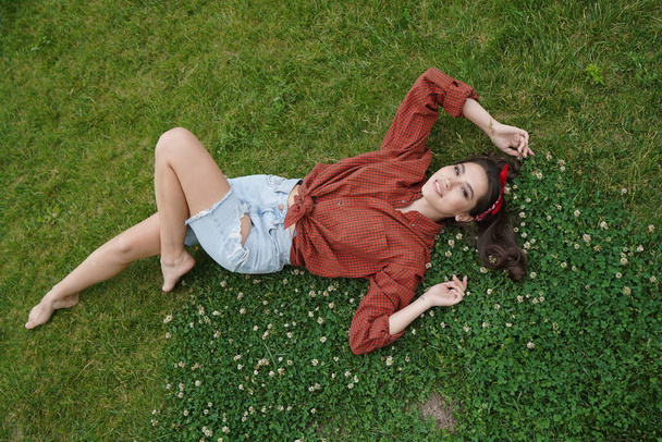 A girl lies on her back on the grass - Zdjęcie, obraz