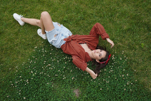 A girl lies on her back on the grass - Foto, afbeelding