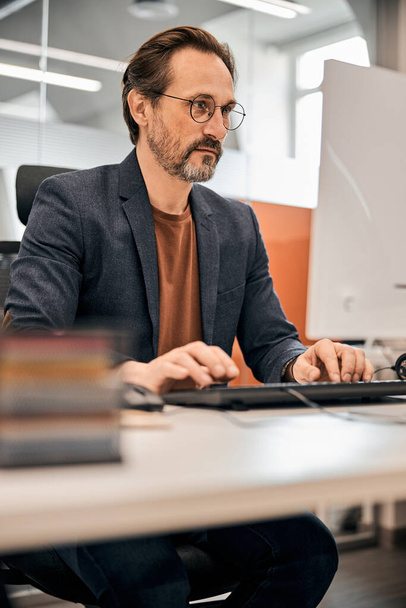Male office worker looking at computer screen - Fotografie, Obrázek