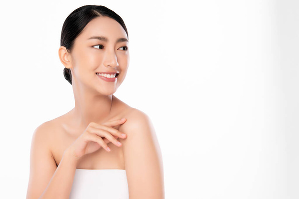Mooie jonge aziatische vrouw aanraken van haar lichaam met frisse gezonde huid, geïsoleerd op witte achtergrond, schoonheid cosmetica en gezichtsbehandeling concept - Foto, afbeelding