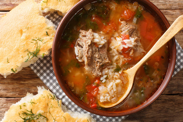 Kharcho leves marhahússal, rizs fűszerekkel és zöldségekkel, grúz kenyérrel az asztalon. vízszintes felülnézet abov-tól - Fotó, kép