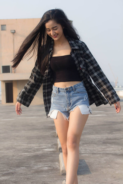 Portrait de thai Chine adulte belle fille chemise noire jeans bleu se détendre et sourire - Photo, image