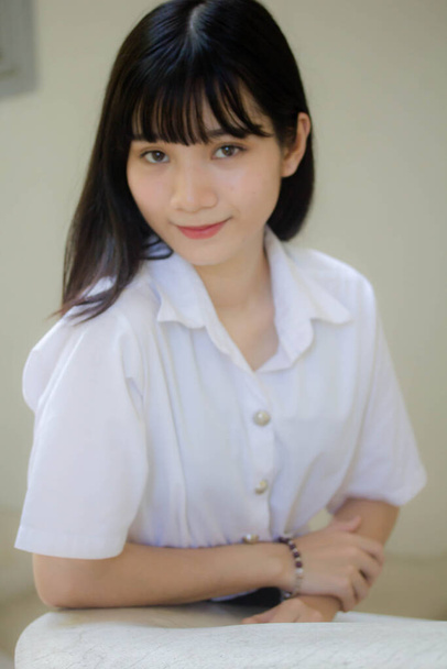 портрет тайского взрослого студенческого университета униформа красивая девушка расслабиться и улыбаться - Фото, изображение
