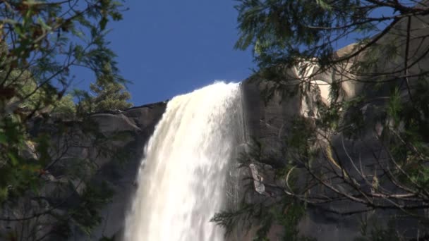 Zamknij wodospad z góry między drzewami - Materiał filmowy, wideo