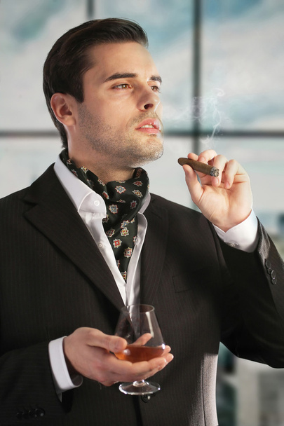 Человек курит сигары и пьет коньяк - Фото, изображение