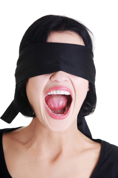 Portrait of young blindfold woman screaming - 写真・画像