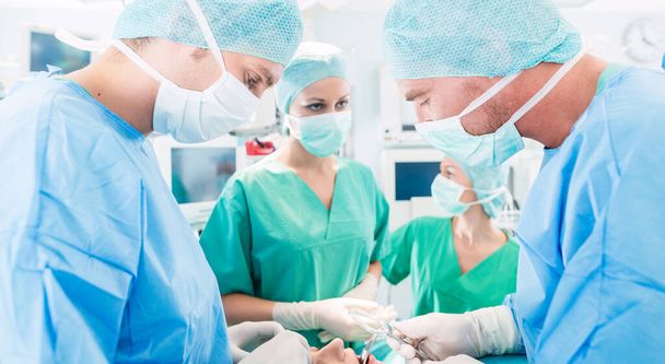 Surgeons or doctors in operating room of hospital - Фото, зображення