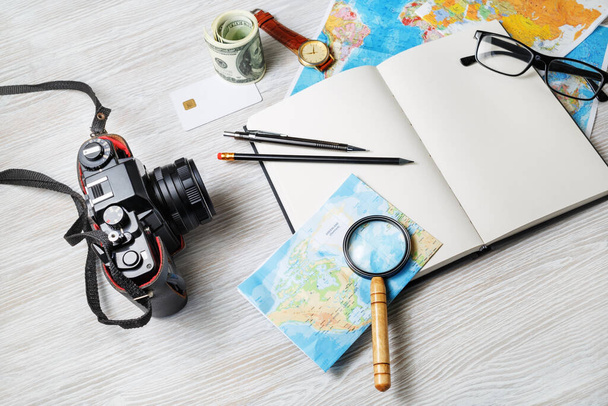 Personal traveler's items. Photo of travel accessories on light wooden background. - Fotó, kép
