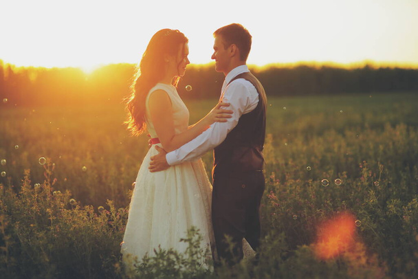 Щаслива наречена і наречена обіймають один одного в парку на заході сонця. Весілля. Щаслива концепція кохання. Високоякісна фотографія
 - Фото, зображення