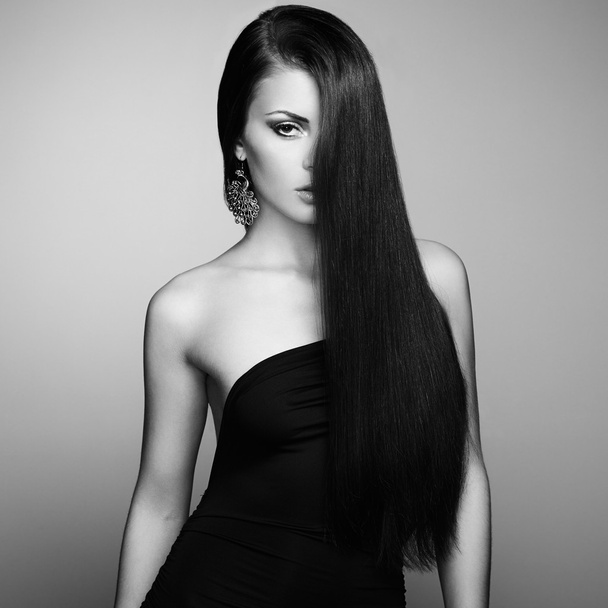 Portrait of beautiful brunette woman in black dress - 写真・画像