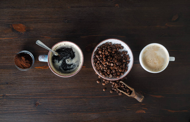 Espresso, taza de café, granos de café y polvo molido sobre fondo de mesa de madera. Vista superior. Puesta plana
. - Foto, imagen