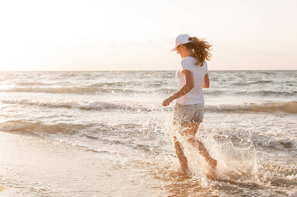 Una giovane donna che corre vicino al mare - Foto, immagini