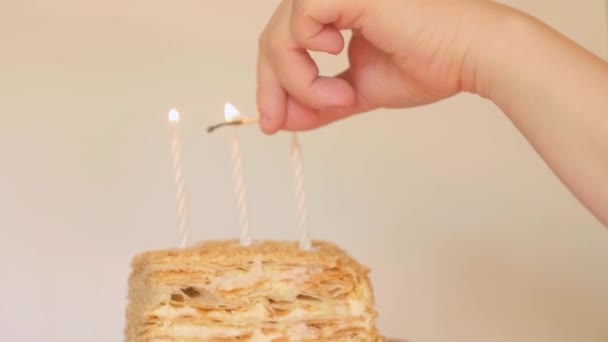 Szoros kéz gyertyát gyújt. Születésnapi torta. Buli hangulat. Ünnepi koncepció - Felvétel, videó