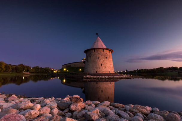 View of the night Pskov Kremlin near the city river on a summer clear day. Beautiful purple sunset over the cityscape. - Foto, immagini