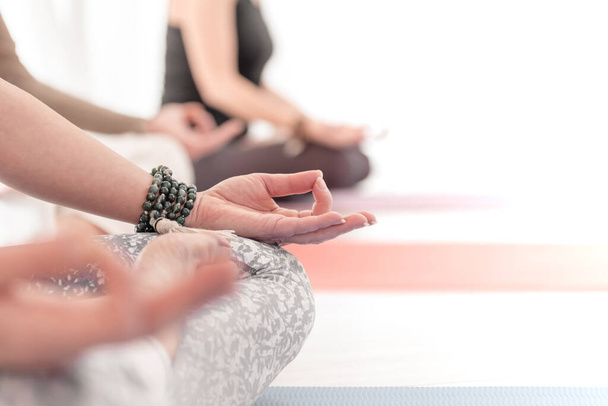 Lähikuva naisellinen ja maskuliininen kädet ja ristissä jalat meditaation aikana. Miten pitää kädet ilmassa varten Kriya tai meditaatio. - Valokuva, kuva