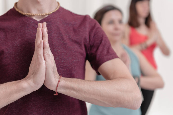 Közelíts rá Namaste gesztusára. A férfi az előtérben, kezével Namaste gesztusában. Hogyan tartsuk a kezünket a levegőben Kriya vagy meditáció céljából?. - Fotó, kép