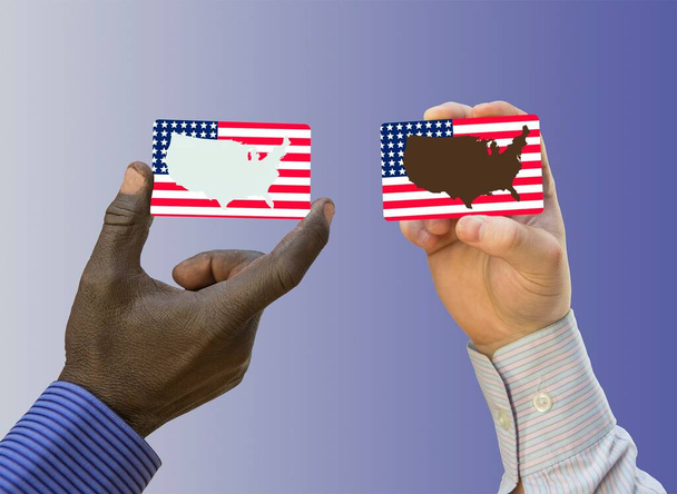 Zwarte levens zijn belangrijk. De handen van een blanke en een zwarte man hebben visitekaartjes met Amerikaanse vlaggen op de landkaart.. - Foto, afbeelding