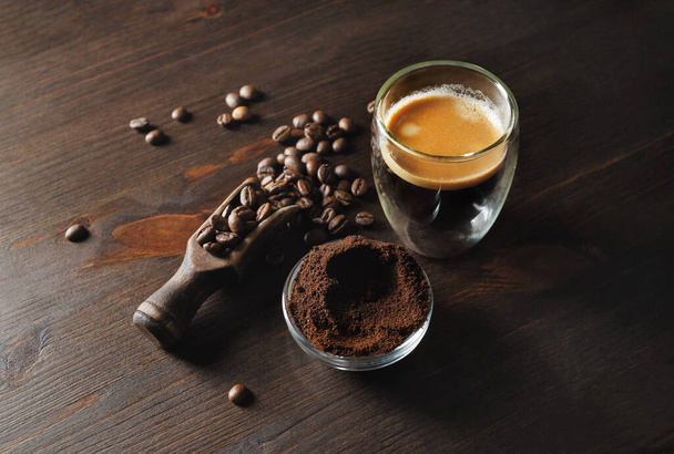 Asetelma kahvia espresso, jauhettua jauhetta ja kahvipapuja puinen keittiö pöytä tausta. Litteä. - Valokuva, kuva