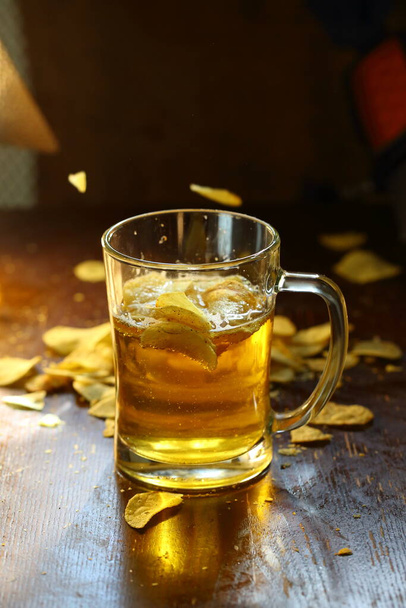 Beer with chips on a wooden background - Photo, Image