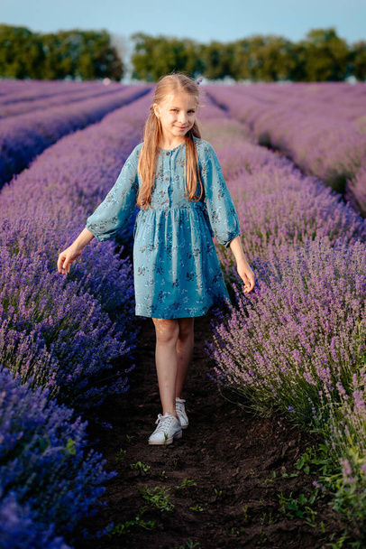 Krásná, šťastná dívka kráčí v levandulovém poli - Fotografie, Obrázek