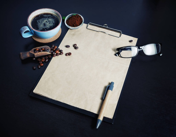 Zestaw do pisania i kawa. Clipboard z pustym papierem kraft, filiżanka kawy, ziarna kawy, długopis, szklanki i proszek ziemi na czarnym tle tabeli. - Zdjęcie, obraz