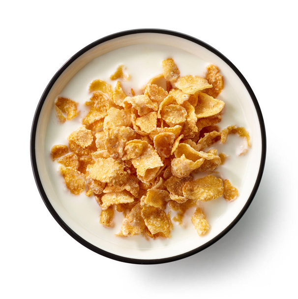 Schüssel mit süßen Cornflakes mit Milch isoliert auf weißem Hintergrund, Draufsicht - Foto, Bild