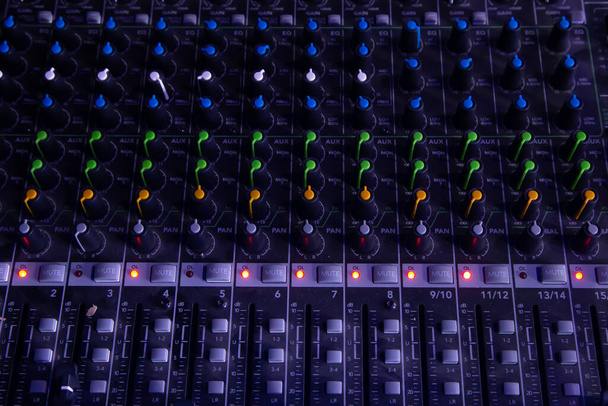 Analoge studio geluidsmixer close-up met laptop en geluidsgolf vorm op de achtergrond. - Foto, afbeelding