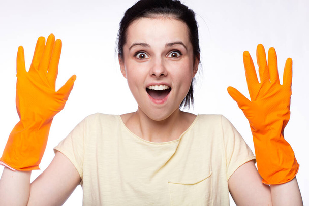 emotional woman in orange cleaning gloves, cleaning company employee - Fotó, kép