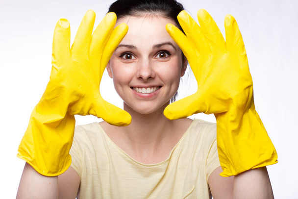 smiling woman in yellow cleaning gloves, white background - Foto, imagen