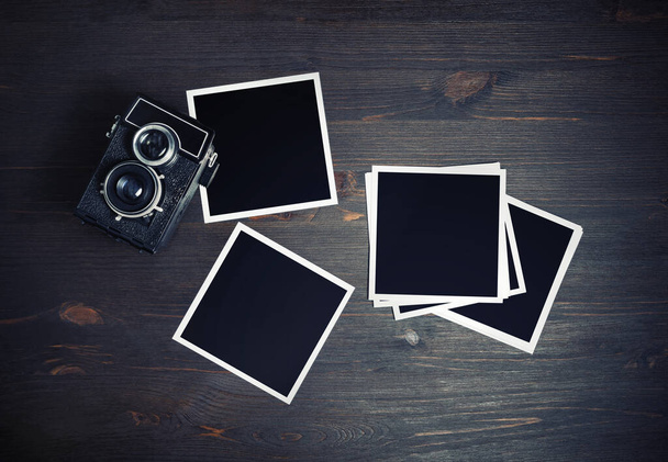Blank photos and vintage camera on wooden background. Square photo frames template. Flat lay. - Photo, Image