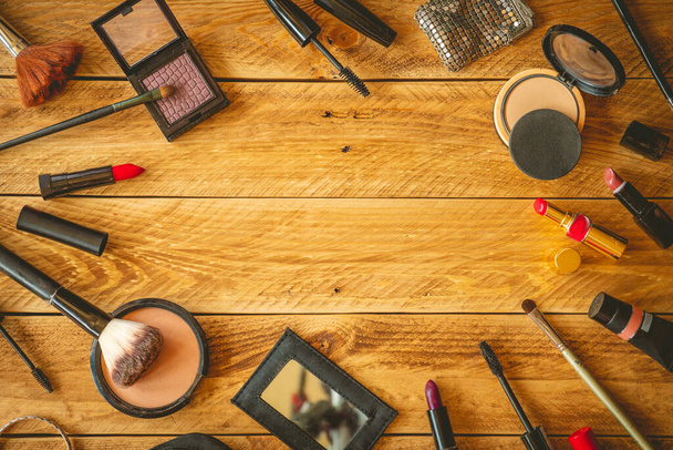 Productos de maquillaje en una mesa de madera con espacio para copiar en el centro
 - Foto, Imagen