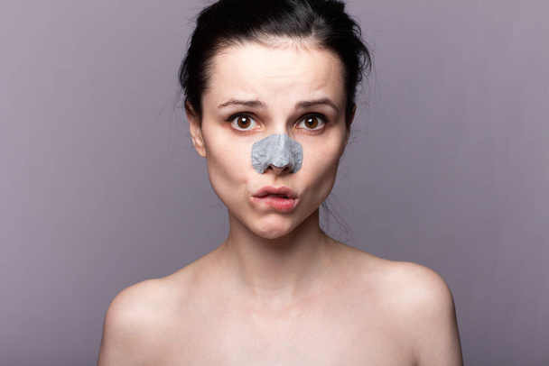 woman in nose strip, problem skin, gray background - 写真・画像