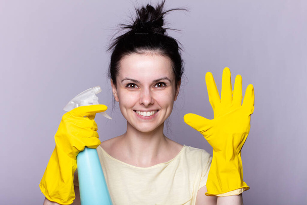 Beautiful happy housewife with rubber gloves with finger near chin - Φωτογραφία, εικόνα