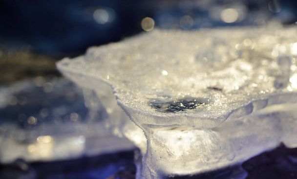 Primo piano di ghiaccio ghiacciato scintillante al sole all'aperto in inverno su sfondo blu - Foto, immagini