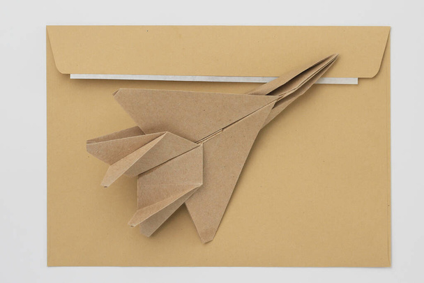 Modèle d'avion en papier Origami. Concentration sélective. Dans le contexte d'une enveloppe postale classique. - Photo, image