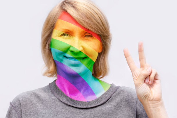 O rosto de uma mulher adulta pintada nas cores do arco-íris
 - Foto, Imagem