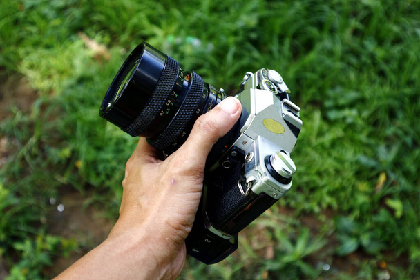 Photo d'un vieux et ancien reflex mono-objectif ou appareil photo reflex dans un parc extérieur. - Photo, image