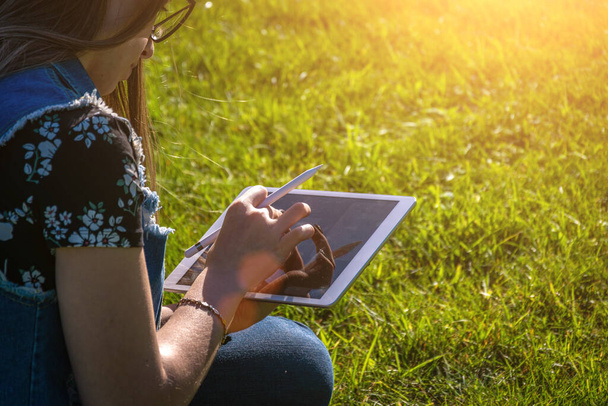 Laptop venkovní obchodní technologie. Studentka pracuje na tabletu, počítač v letním parku. Online žena v přírodě venku. Happy hipster mladé dálkové vzdělávání koncept - Fotografie, Obrázek