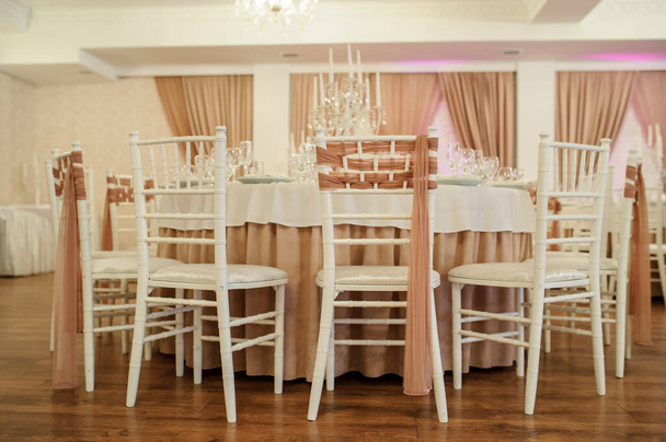 Etkinlik için süslenmiş bir ziyafet salonundaki beyaz ve kahverengi renkli bir masayı kapatın. - Fotoğraf, Görsel