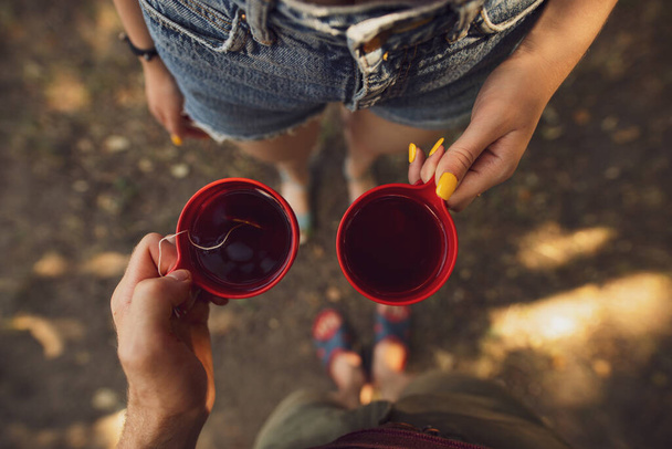 Couple holding cups with tea - Foto, afbeelding