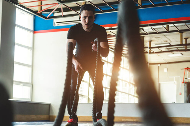 Crossfit. The athlete is training in the gym. photography through the ropes - Foto, Imagen