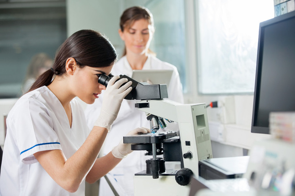 Female Researcher Looking Through Microscope - Фото, изображение
