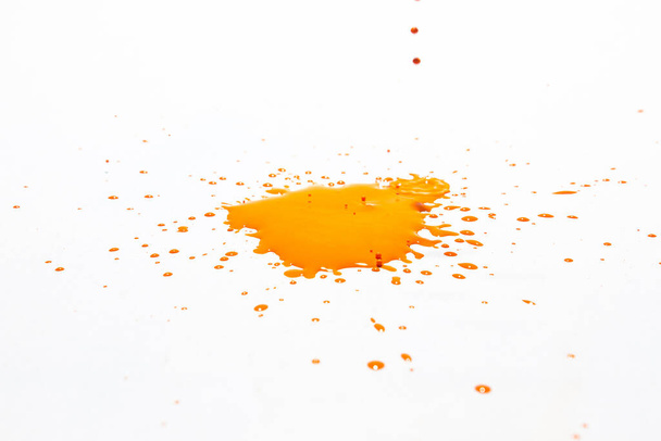 Gouttelettes d'eau orange éclaboussant sur un fond blanc - Photo, image