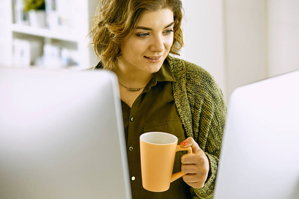 Young woman working with graphic tablet in office - Foto, afbeelding