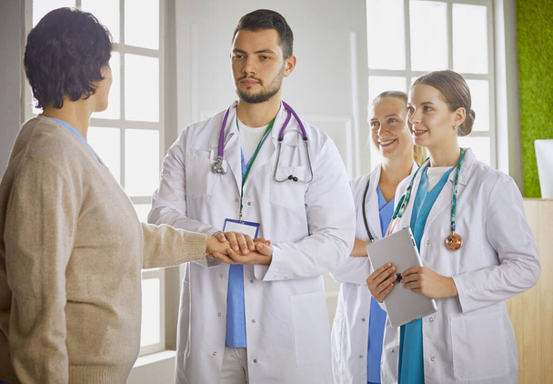 Patient mit einer Gruppe von Ärzten im Hintergrund - Foto, Bild