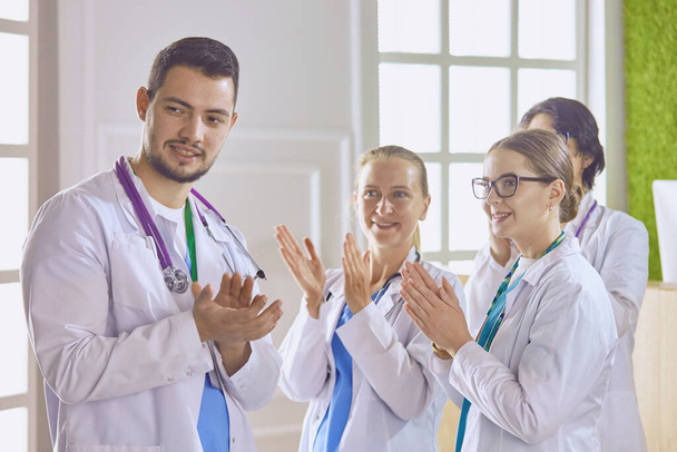Счастливая команда врачей, состоящая из мужчин и женщин, широко улыбается и дает большой палец вверх успеха и надежды - Фото, изображение