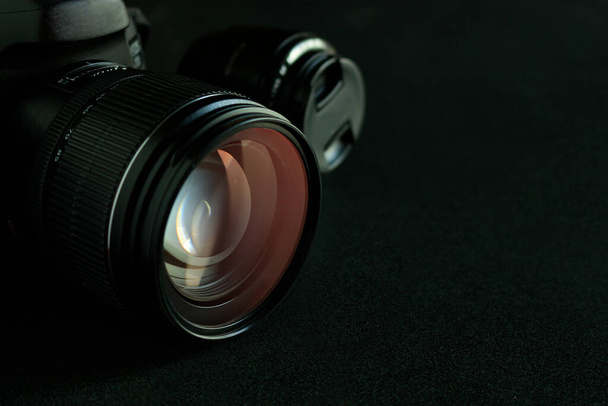 cámara digital de primer plano sobre mesa de madera negra con enfoque suave en el fondo. tono de color oscuro y sobre la luz
 - Foto, Imagen