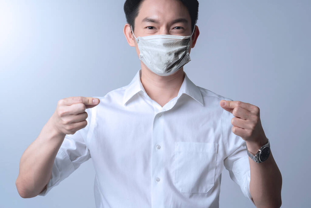 幸福スマート魅力的なアジアの男性白いシャツ身に着けている保護マスクの広がりからcovid-19コロナウイルスoutbreaskパンデミックの健康と病気のアイデアの概念白い背景 - 写真・画像