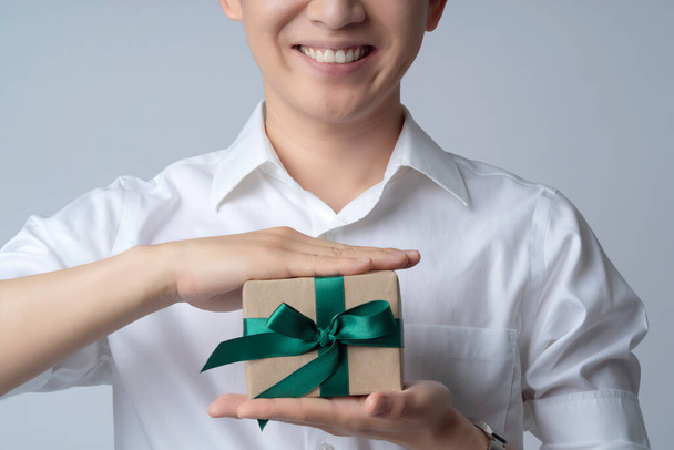 closeup business communication ideas concept with asian attractive male casual tshirt hand hold brown present gift box smile and happiness hand gesture pose present point show joyful moment - 写真・画像